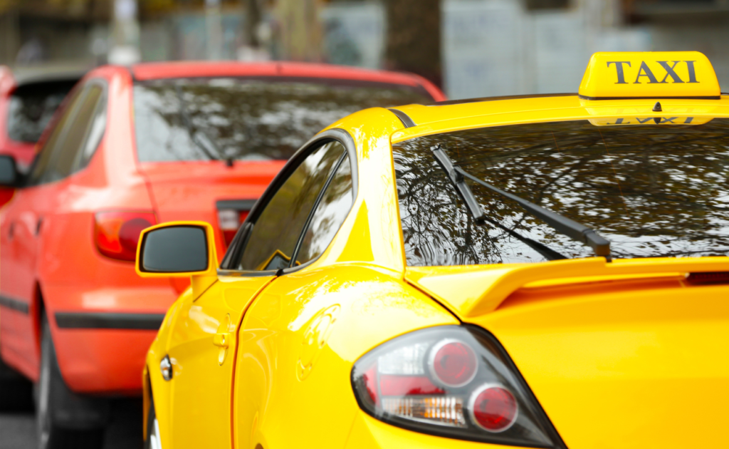 A taxi behind a red car